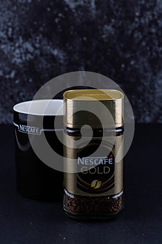 Selangor, Malaysia - April 2020: Nescafe gold instant coffee in a jar with black cup over dark background