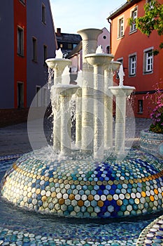 Selb, Germany - September 21, 2023: Porcelain fountain on Martin Luther Square with the Church of Saint Andrew. Selb is known for