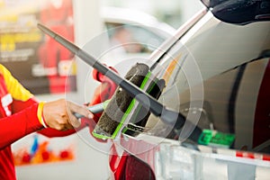 Selcective focus to staff using squeegee to clean the Rear window car.