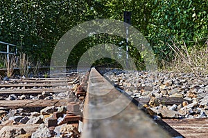 Seldom used, weathered railway line that is gradually overgrown by plants