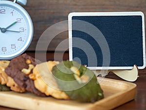 Select focus of blackboard behind of multiple color cookies inclusive peanut butter, green tea cookies, and Chocolate Chip Cookies