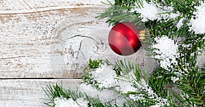 Red ball ornament for Christmas holiday with evergreen and snow