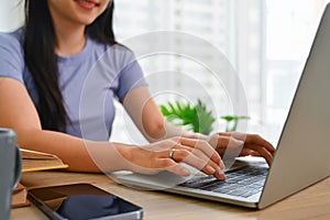 Select focus on woman hands typing on laptop keyboard, searching information, working or working online