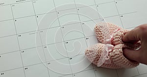 Selected due date on calendar and details of baby pink shoes