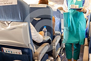 Selected focus bottle water with flight attendant serve drink to passengers on board.