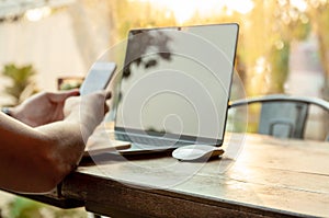 Selected focus computer mouse with man using cell phone and laptop on the table.