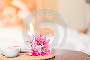 Selected focus a flower in spa and massage room with blurred of candle light and people as a background