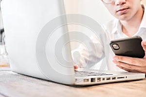 Selected focus hand asian businessman or student working on laptop and using smartphone