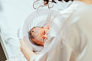 Selected focus on little a cute hungry new born baby boy crying on her mother hand.