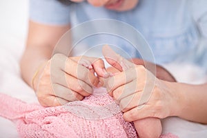 Selected focus on mother hands holds little baby covered by pink