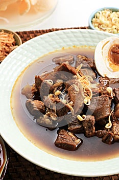 Selected Focus Rawon, Indonesian Traditional Beff Black Soup from East Java. Served on a Bowl wth Shrimp Cracker kerupuk Udang