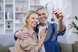 Selected focus, senior gray-haired couple, man and woman hugging together in new apartment house, happy family holding
