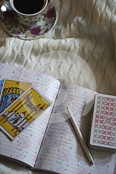 Selected focus of tarot cards layout, cup of Coffee and notebook.