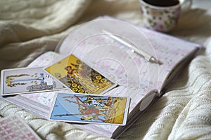 Selected focus of tarot cards layout, cup of Coffee and notebook.