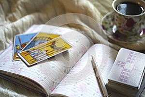 Selected focus of tarot cards layout, cup of Coffee and notebook.