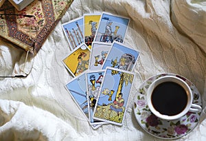 Selected focus of tarot cards layout, cup of Coffee and notebook.