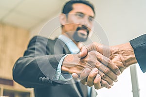 Selected focus on two businessman hands shake in the meeting room. Businessmand hand shake as a greeting