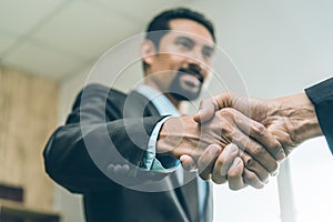 Selected focus on two businessman hands shake in the meeting room. Businessmand hand shake as a greeting