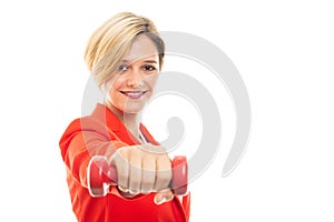 Selected focus of young business woman showing red dumbbell