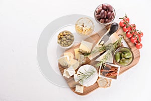 Selection of cheeses served with variety of antipasti - olives, baby and sun dried tomatoes, pickled artichokes, capers