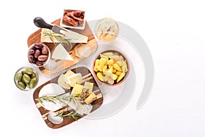 Selection of cheeses with variety of antipasti on wooden boards - olives, baby and sun dried tomatoes