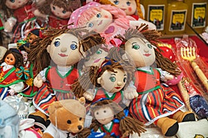 Selection of children's plush toys, including dolls and teddy bears, arranged neatly on a tabletop