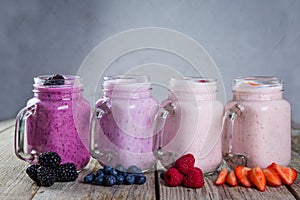 Selection of colorful detox berry drinks on wood background