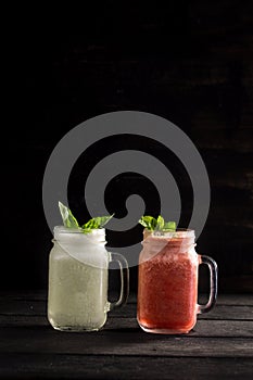 Selection of colorful detox drinks in mason jar on black background