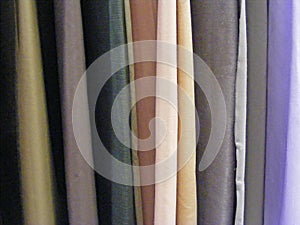 Selection of colorful fabrics for curtains, rolls of fabrics. Woolen, textiles.