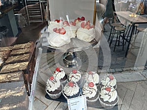 A selection of delicious cakes through a bakery window