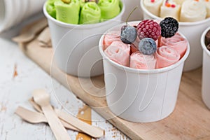 Selection of different rolled ice creams in cone cups