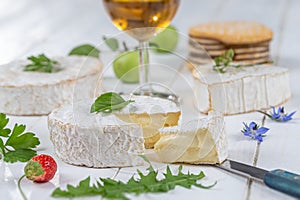 Selection of different types of cheese. Tasty and fresh cheese, with glass of Cider, White wooden background