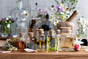 Selection of essential oils with herbs and flowers