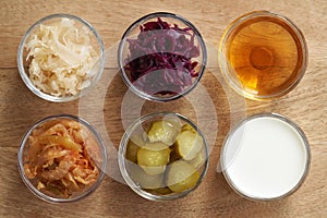 Selection of fermented foods - kim chi, white and purple sauerkraut, apple cider vinegar, gherkins and kefir