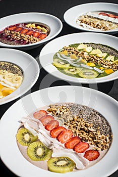 A selection of five different Smoothie bowl with different fruits, yogurt, granola and nut seeds