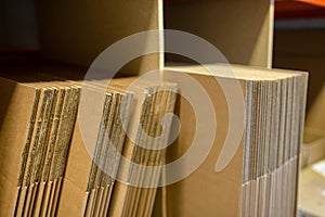 A selection of flat shipping boxes/cartons on a shelf ready to be made up and packed with product. Warehouse, despatch, shipping,