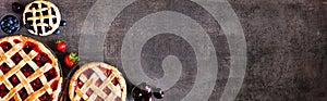 Selection of fresh fruit pies. Above view corner border over a dark stone background with copy space. photo