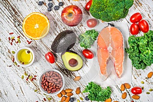 Selection of fresh fruit and vegetables, salmon, beans, and nuts.