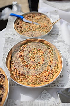 Selection of freshly-baked pies arranged on white paper with knives, ready to be enjoyed