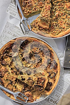 Selection of freshly-baked pies arranged on white paper with knives, ready to be enjoyed