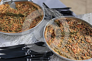 Selection of freshly-baked pies arranged on white paper with knives, ready to be enjoyed