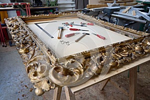 Selection of gold and silver tools with a golden frame on a wooden table