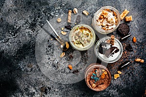 Selection of gourmet flavours of Italian ice cream served in jar on dark rustic table in an ice cream parlor, banner, menu, recipe