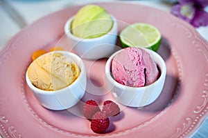 Selection of gourmet flavours of Italian ice cream in vibrant colors served in individual porcelain cups on an old