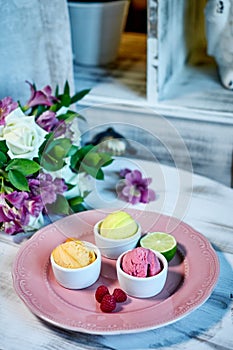 Selection of gourmet flavours of Italian ice cream in vibrant colors served in individual porcelain cups on an old