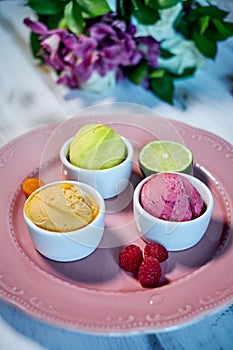 Selection of gourmet flavours of Italian ice cream in vibrant colors served in individual porcelain cups on an old