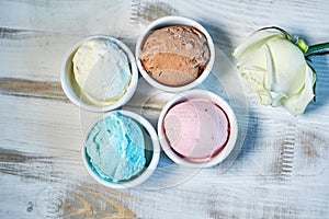 Selection of gourmet flavours of Italian ice cream in vibrant colors served in individual porcelain cups on an old