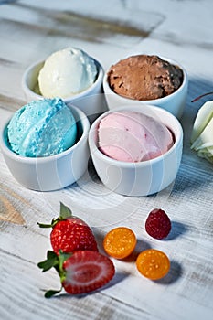 Selection of gourmet flavours of Italian ice cream in vibrant colors served in individual porcelain cups on an old