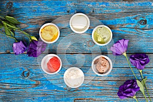 Selection of gourmet flavours of Italian ice cream in vibrant colors served in individual porcelain cups on an old rustic wooden t