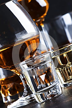 Selection of hard alcoholic drinks in big glasses and small shot glass in assortent: vodka, rum, cognac, tequila, brandy and